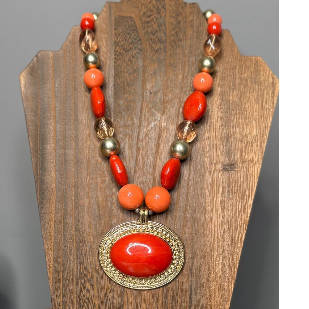 Coral Red, Orange, Peach, Plastic Pendant Gold toned on beaded necklace.